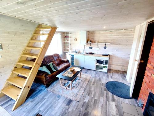LieplaukėCharming Sauna Cottage in a Horse Ranch的一个小房子里带楼梯的客厅