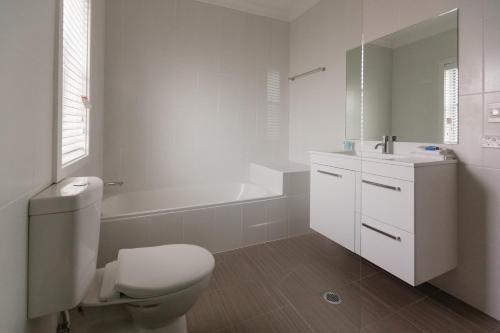 纽卡斯尔汉密尔顿埃弗顿酒店的浴室配有卫生间、盥洗盆和浴缸。