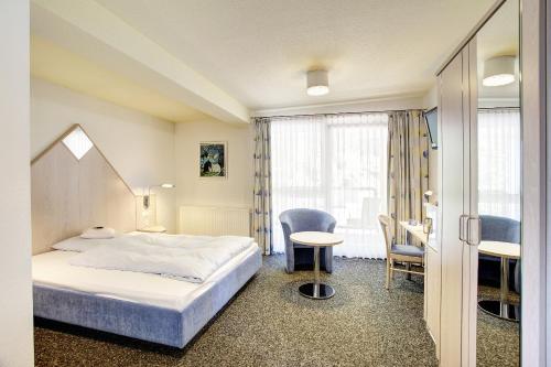 圣英贝特alfa hotel的酒店客房带一张床、一张桌子和椅子