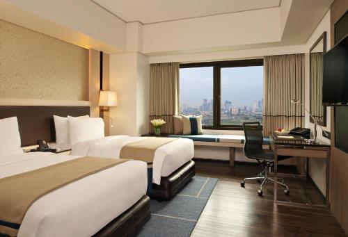 马尼拉Seda Bonifacio Global City的酒店客房配有两张床和一张书桌