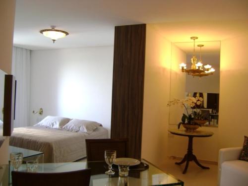 累西腓Boa Viagem 420 Apart Hotel的酒店客房,配有一张床铺和一张桌子,还有一间客房