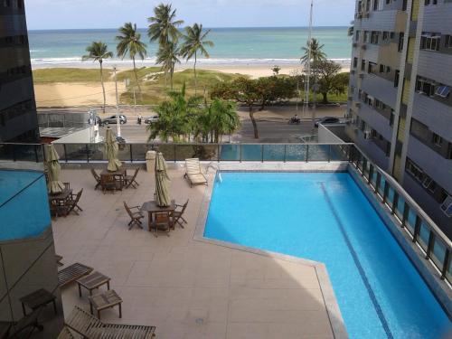 累西腓Boa Viagem 420 Apart Hotel的从酒店阳台可欣赏到游泳池和海滩的景色