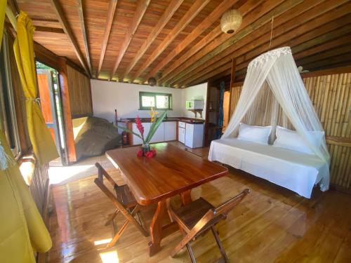 Opoa法尔欧碧日旅舍的一间卧室配有一张床、一张桌子和一张床