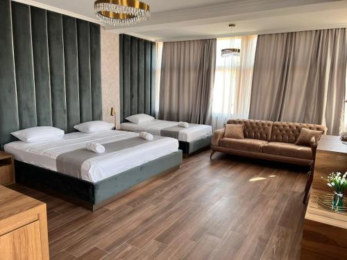 第比利斯Tbili Metekhi Boutique Hotel的酒店客房,设有两张床和一张沙发