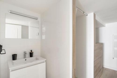 鲁瓦扬Appartement 200 m plage avec terrasse et jardin的白色的浴室设有水槽和镜子