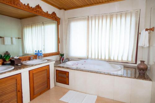 TaungooKMA Kaytumadi Hotel的一间带两个盥洗盆和大浴缸的浴室