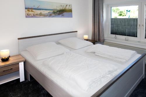 高尔维茨FeWo Pusteblume的一张带两个枕头和窗户的大型白色床