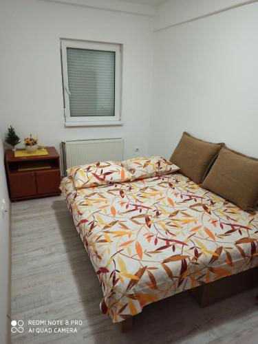 尼什Mila lux的一间卧室配有一张带五颜六色棉被的床