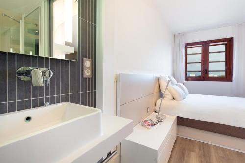 佩皮尼昂Novotel Suites Perpignan Centre的白色的浴室设有水槽和一张床