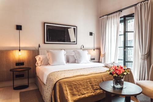马略卡岛帕尔马非凡桑特佛兰西斯可酒店的酒店客房,配有床和鲜花桌