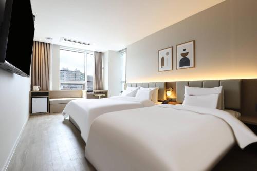 原州市Wonju Brown Dot Hotel Corporate Business的酒店客房设有两张床和窗户。