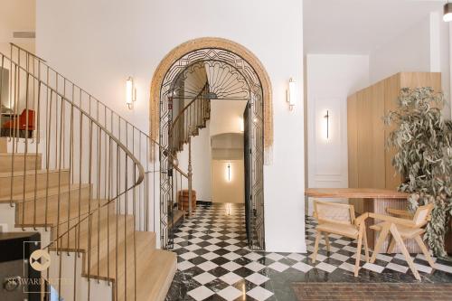 比利亚霍约萨Castelar Palace & SPA by Seaward Suites的走廊设有拱门、桌子和楼梯