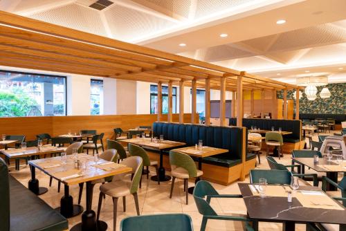 伊斯兰蒂拉安提亚港大酒店的配有木桌和桌椅的餐厅