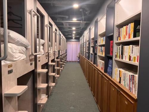 东京Book Tea Bed SHIBUYA的图书馆的走廊,书排成行