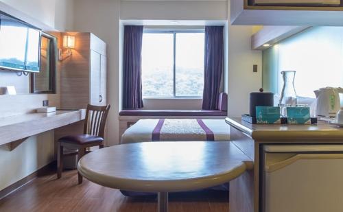 碧瑶碧瑶市温德姆麦克罗特酒店的小房间,配有一张床和一张桌子