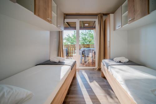 克罗诺维察Luxury Home Sanella的带窗户的客房内的两张床