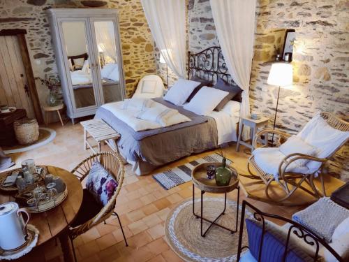 Le Pont Réan库提隆庄园住宿加早餐旅馆的卧室配有一张床和一张桌子及椅子