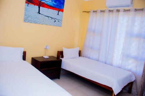 龙杜Home@Amalia’s的带窗户的客房内设有两张单人床。