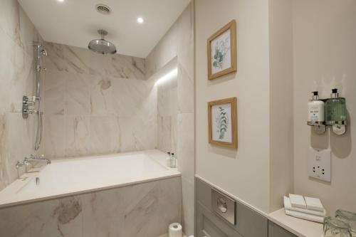 TarlandDouneside House的白色的浴室设有浴缸和水槽。