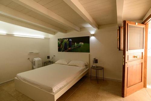 圣安吉罗山Dimora Mariuccia的卧室配有一张床,墙上挂有绘画作品