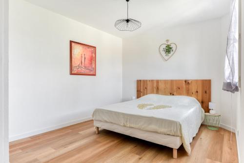 纳博讷La Villa d'Isa et Seb的一间铺有木地板的白色卧室,配有一张床