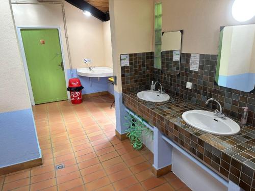 ArtigatLES EYCHECADOUS的一间带两个水槽和绿门的浴室