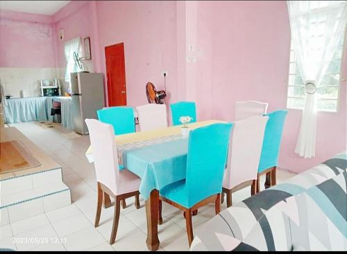 TuaranDiana Home @ Tuaran的一间配备有蓝桌和白色椅子的用餐室