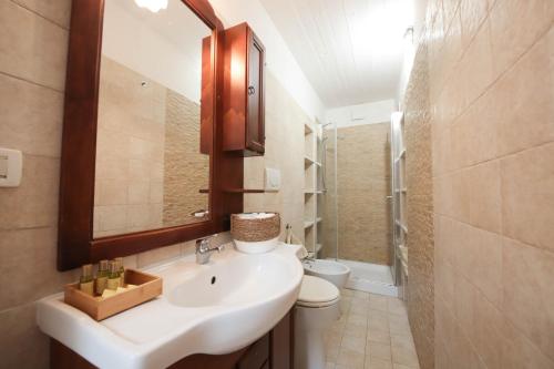 莫诺波利Villa Dyria exclusive swimming pool的一间带水槽、卫生间和镜子的浴室
