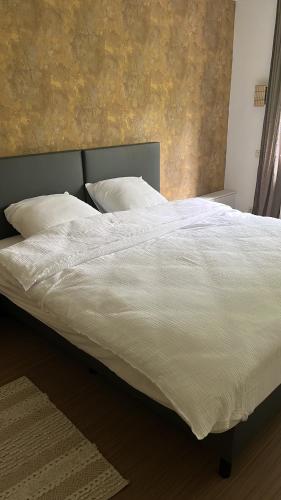 奥斯特坎普Vakantiewoning Blijbos的卧室内的一张带白色床单和枕头的床