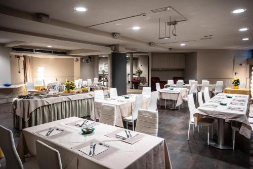蒙特瓦尔基德尔塔酒店的用餐室配有白色的桌子和白色的椅子