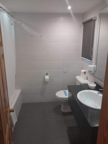 沙拉聚宝盆酒店的白色的浴室设有水槽和卫生间。