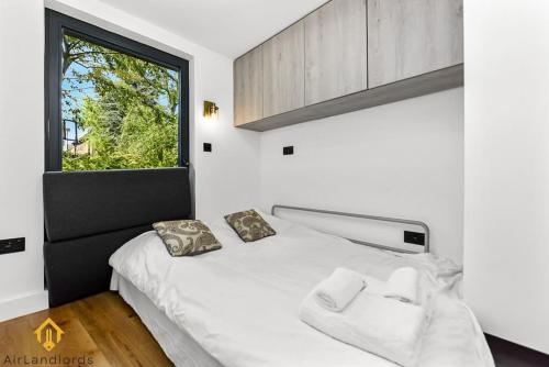 伦敦Charming Modern Chic Pad Summer House的卧室配有白色的床和窗户。