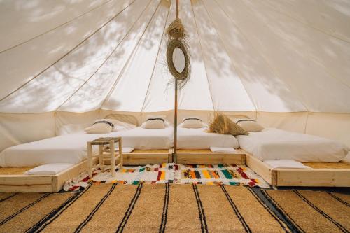 巴利-略夫雷加Camping 3 Estrellas Costa Brava的帆布帐篷内的两张床,铺着地毯