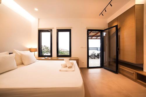 卡利诺岛Blue Dawn Kalymnos的卧室配有一张白色大床,部分设有窗户