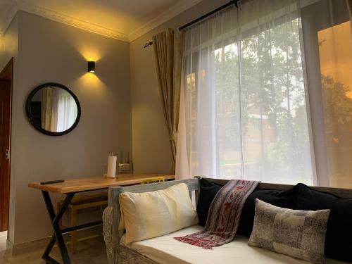 内罗毕Kingfisher Cottage的带沙发、桌子和窗户的客厅
