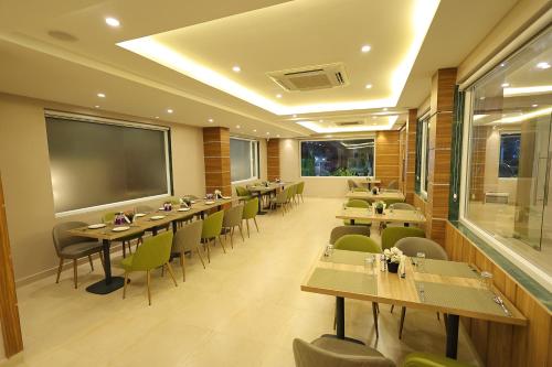 巴特那Hotel Sharda Residency的一间带桌椅和大屏幕的餐厅