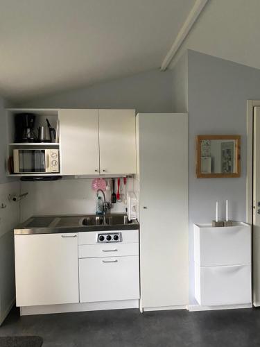 法尔肯贝里Liten ”stuga”的厨房配有白色家电和白色冰箱