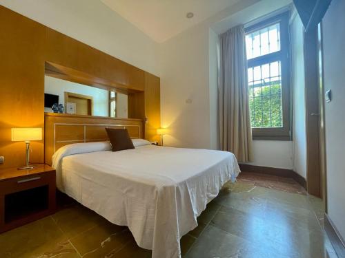 隆达阿希尼普酒店的一间卧室设有一张床和一个大窗户