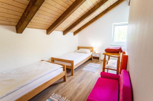 克拉皮纳Apartmani Cerovečki的一间设有两张床和椅子的房间