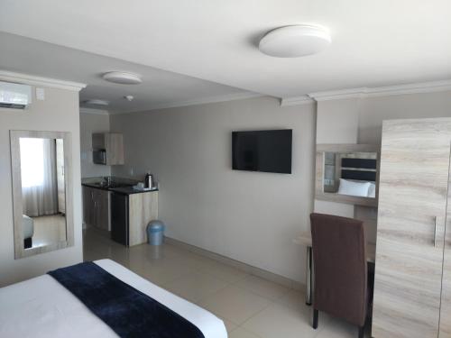 谢普斯敦港Bayside Taj Hotel的酒店客房设有一张床和墙上的电视