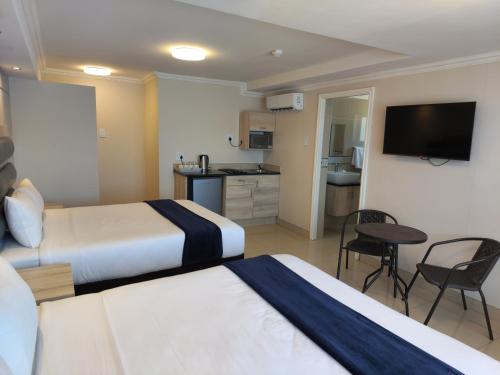 谢普斯敦港Bayside Taj Hotel的酒店客房带两张床和厨房