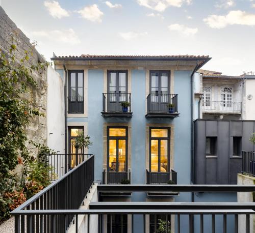 波尔图Laranjais Boutique Suites & Apartments Porto的拥有蓝色外墙和阳台的房子