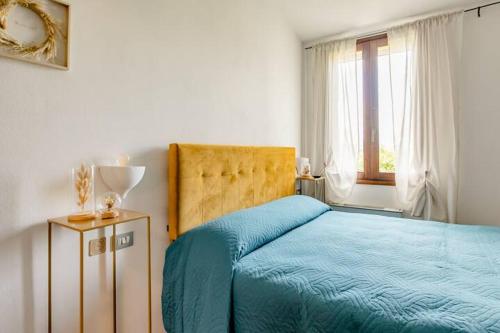 杰马诺Locanda delle grotte di Onferno的一间卧室设有蓝色的床和窗户。