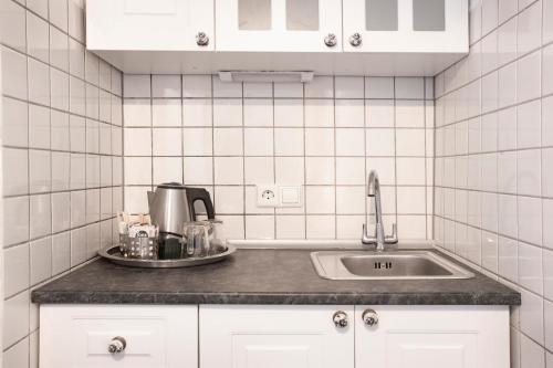 Hillscheid哈特恩穆尔希尔赛德酒店的白色瓷砖厨房配有水槽和柜台