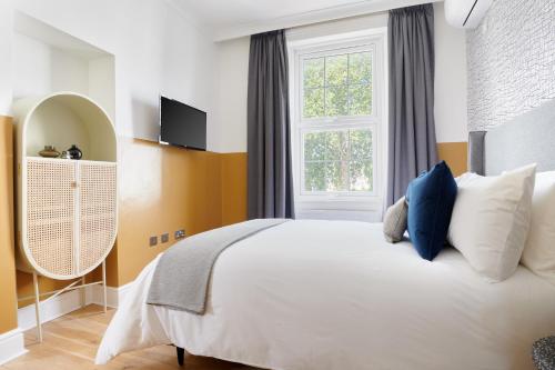 伦敦Sonder Camden Road的卧室配有白色的床和窗户。