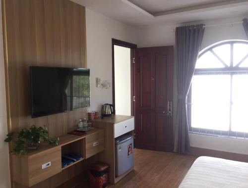Xóm Mỹ CaLong Hồ Homestay的卧室设有平面电视和窗户。