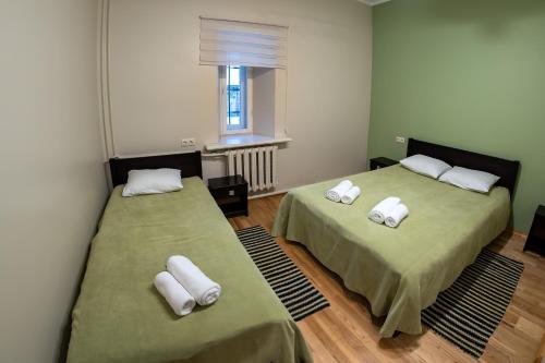 Milzkalne庄园住宅酒店的一间设有两张床铺和毛巾的房间