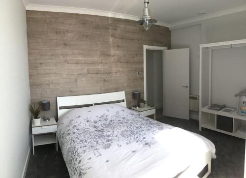 LimekilnsThe Bolthole的卧室配有白色的床和木墙
