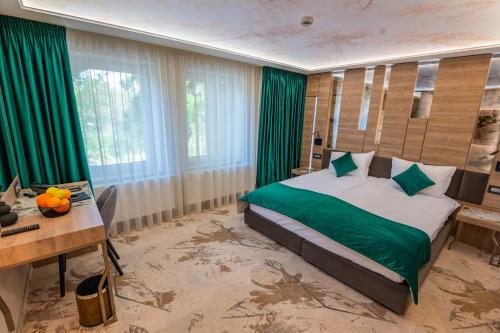 比斯特里察Hotel Codrişor的一间卧室配有一张带绿色床单的床和一张桌子