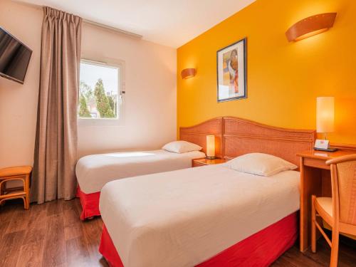 奥尔泽姆B&B HOTEL Strasbourg Aéroport的酒店客房设有两张床和窗户。